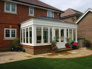 white timber orangery on red brick home